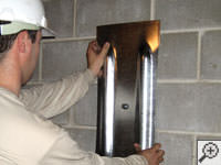 Mounting a foundation wall plate for an earth anchor installation in Layton.