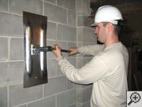Attempting to straighten a bowed foundation wall by straightening a wall anchor system in a Sandy home.