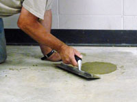 Repairing the cored holes in the concrete slab floor with fresh concrete and cleaning up the Sandy home.