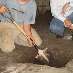 Digging a hole for the engineered fill used in a crawl space support system installation in Tooele