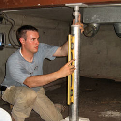 A contractor in Layton installing a crawl space jack post.
