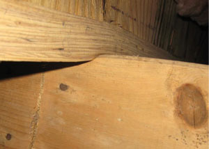 A failing girder showing signs of compression damage in a Utah home