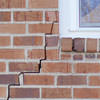 long jagged cracks starting at the corner of a window along a brick wall on a American Fork home