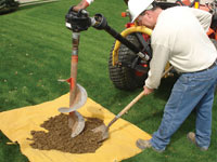 Auguring a hole in the earth for a foundation wall repair system in Sandy