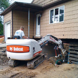 Excavating to expose the foundation walls and footings for a replacement job in Layton