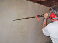 Drilling the hole in the foundation wall for street creep repairs in Kaysville