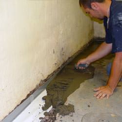 A basement waterproofer installing a perimeter drain system in Cedar City