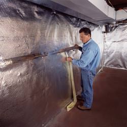 Installation of a radiant heat and vapor barrier on a basement wall in Lehi