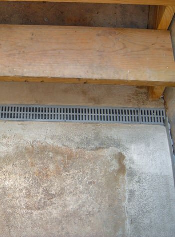 A grated basement drain weeping tile system for use with flooded hatchway doors