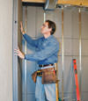 Insulated basement wall panels being placed against a concrete foundation wall in Saratoga Springs